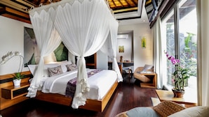 A spacious bedroom with a large bed, a sitting area, and a view of the outdoors. - SPV 8008 · LUXURY JIMBARAN VILLA BY THE BEACH (Bali)