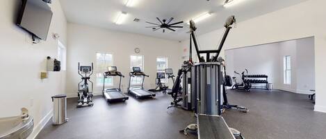 A gym with treadmills, elliptical machines, and weight equipment.