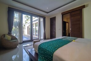 A bedroom with a large bed, a wicker chair, and a sliding glass door leading to an outdoor area. - MariJo Villa·2BR Private Pool mins to Central Ubud (Bali)