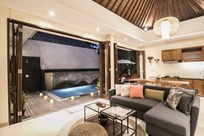 A modern living area with a sofa, coffee table, and a view of a hot tub. - MariJo Villa·2BR Private Pool mins to Central Ubud (Bali)