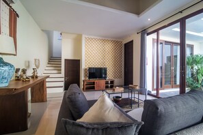 Una sala de estar moderna con un sofá, una mesa de centro y un mueble para televisión.