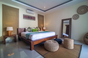 Un dormitorio moderno con una cama de madera, dos mesitas de noche, un espejo grande y almohadones decorativos.