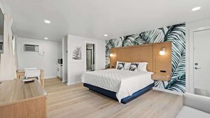 Un dormitorio moderno con cama, mesitas de noche, un armario y una pared con diseño de hojas.