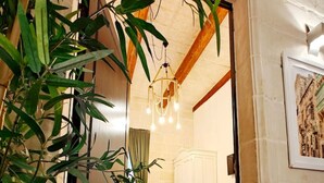Un dormitorio con cama, mesita de noche, cómoda y un ventanal grande.