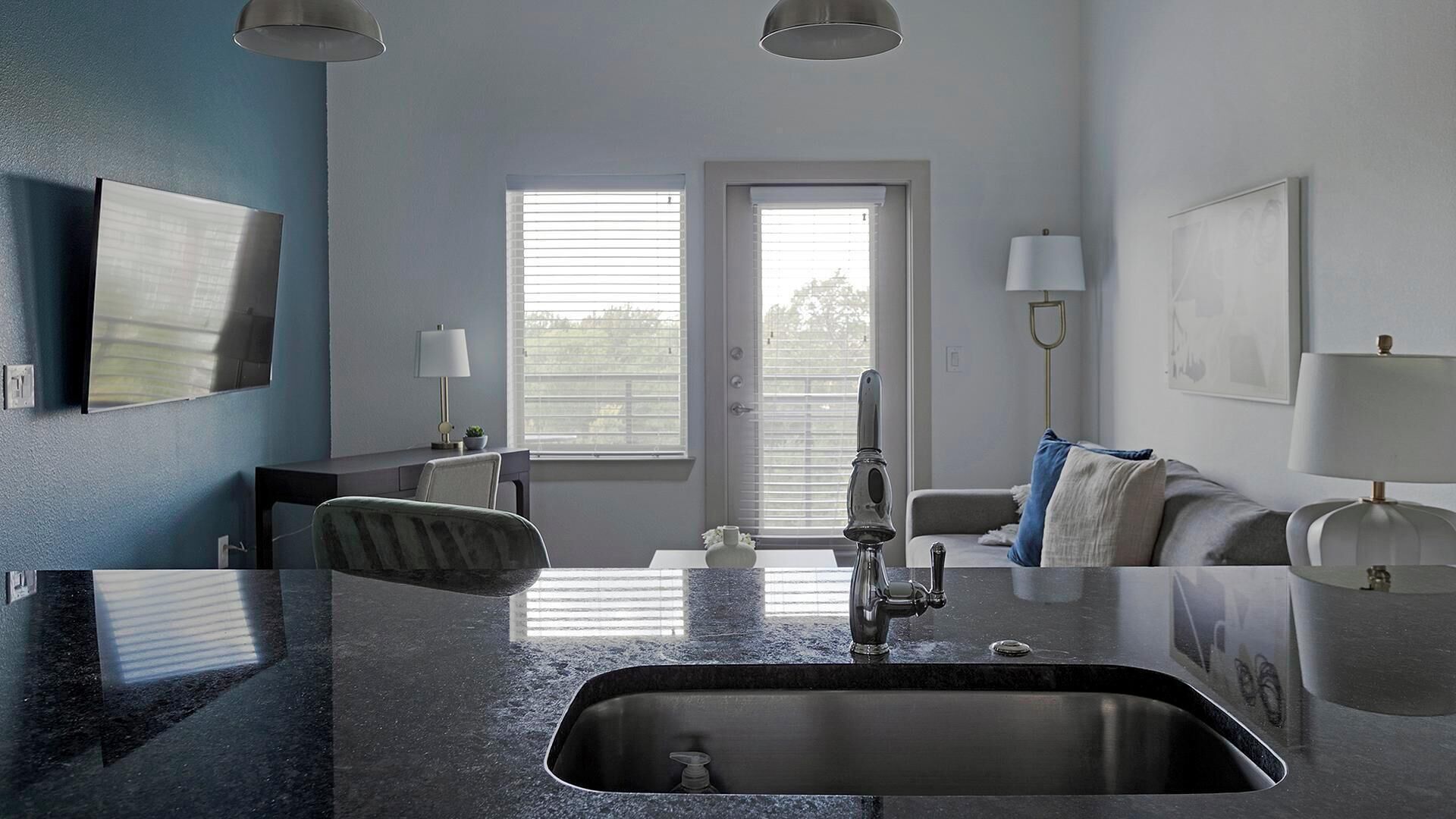 Uma cozinha moderna com uma pia grande, área de jantar com mesa e cadeiras, e janela que oferece luz natural.
