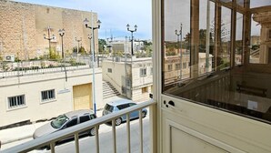 En balkon med udsigt over en gade og bygninger.