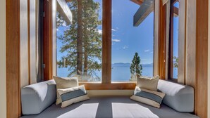 Eine gemütliche Sitzecke mit Blick auf einen See und Berge.