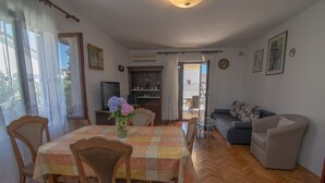 Un salon comprenant un coin repas, un canapé et un téléviseur.