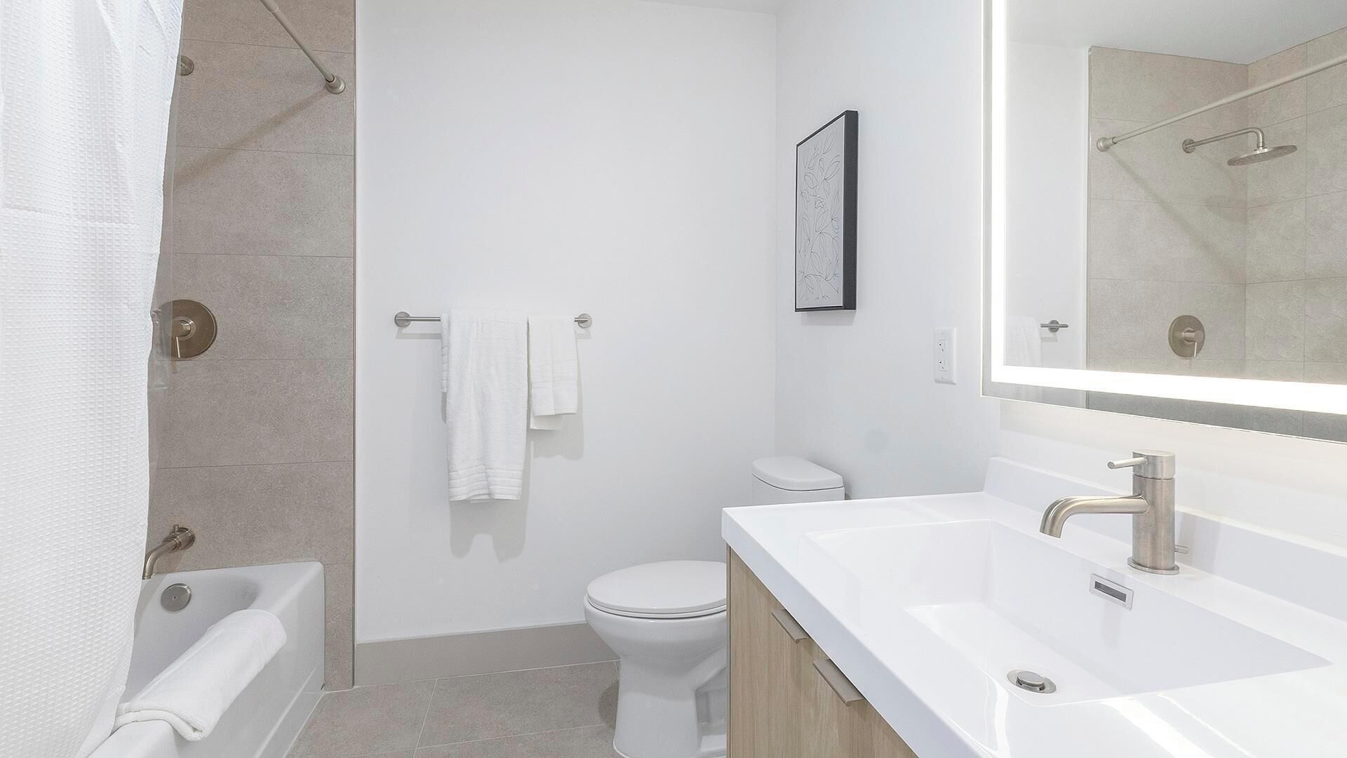 A modern bathroom with a bathtub, toilet, and sink.