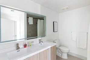 A modern bathroom with a white vanity, a large mirror, a shower area, and a toilet. - Landing | Beautiful 2BD, Clubhouse, Yoga Studio (North Miami)