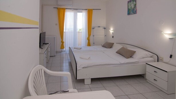 A hotel room with a bed, bedside tables, a chair, a desk, and a TV. - Sv. Martin / B&B sv Martin C, pogled na more (Mali Lošinj)