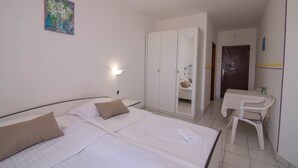 A hotel room with a bed, a desk, a wardrobe, and a painting on the wall. - Sv. Martin / B&B sv Martin C, pogled na more (Mali Lošinj)