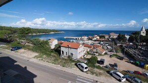 Une ville côtière où se côtoient des immeubles résidentiels et commerciaux, une église imposante et un port de plaisance rempli de bateaux.