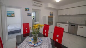 Une chambre d’hôtel de taille réduite comprenant un coin repas, une kitchenette et un lit.
