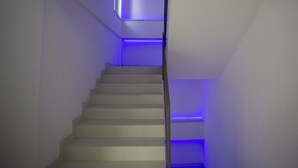 A narrow staircase with a modern design, featuring a blue accent lighting along the steps and a small window at the top. - Stromboli Sunset with shared pool (Villaggio del Golfo)