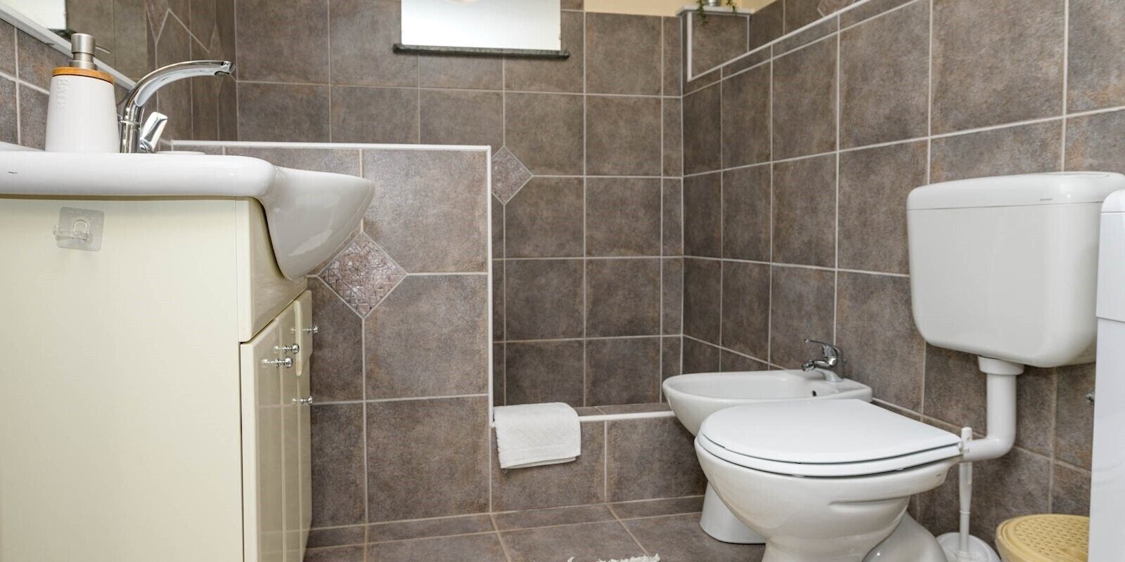 Ein Badezimmer mit Toilette, Bidet und Waschbecken.