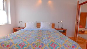 A bedroom with a bed, two bedside tables, a window, and a door. - Frantin / Frantin B4 (Mali Lošinj)