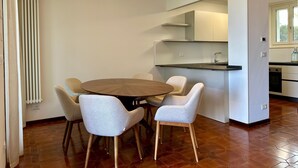 A modern kitchen with a dining area, a radiator, and a window. - Villa Venezia Garda: Lake View, Garden & Jacuzzi (Garda)