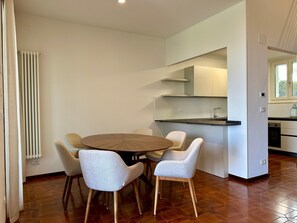 Una cucina moderna con zona pranzo, termosifone e finestra.