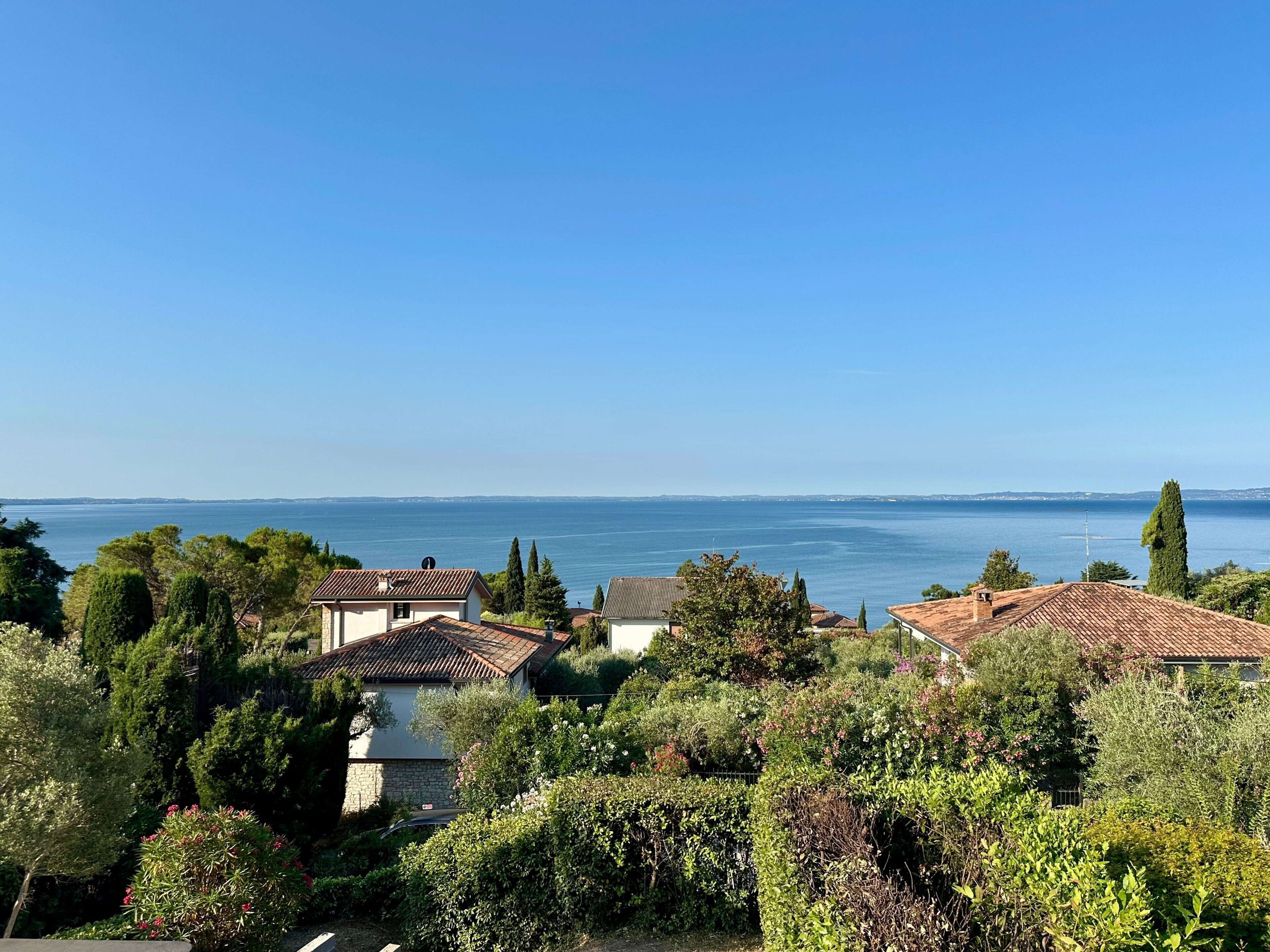 Ein Küstenwohngebiet mit Häusern, üppigem Grün und freiem Blick aufs Meer.