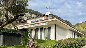A two-story building with a satellite dish, a balcony, and a garden area. - Villa Venezia Garda: Lake View, Garden & Jacuzzi (Garda)