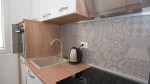 A compact kitchen with a wooden countertop, a sink, and a kettle. - Ivana C6 in Veli Lošinj (Veli Lošinj)