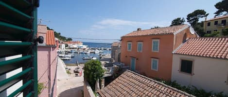 A coastal town with traditional buildings, a marina, and a clear view of the sea.