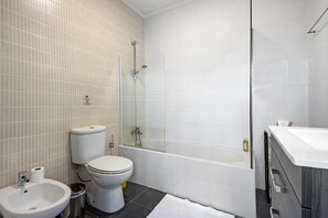 A modern bathroom with a toilet, bidet, sink, and a glass-enclosed shower area. - Holiday Home 'Douro Garden House and Pool' with Private Pool, Wi-Fi and Air Conditioning (Vila Nova de Gaia)