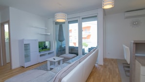 Ett modernt vardagsrum med en soffa, en tv och ett litet bord.