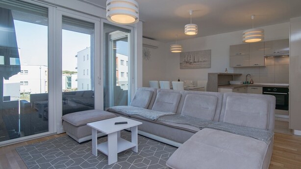 En modern lägenhet med en soffa, ett litet bord och ett köksutrymme.