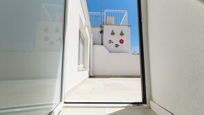 A narrow corridor leading to a balcony with a white railing and a small window. - Casa F&G with Terrace by Wonderful Italy (Ostuni)
