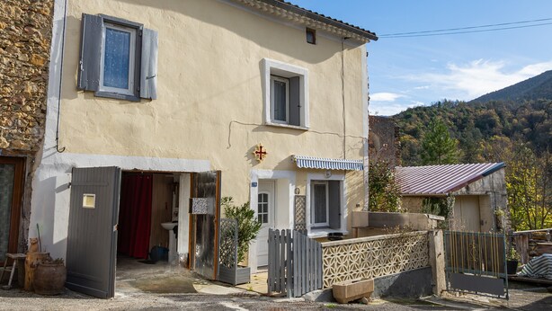 A two-story building with a stone facade, a small porch, and a gate. - House in a Hamlet in the Heart of Cathar Country (Quillan)