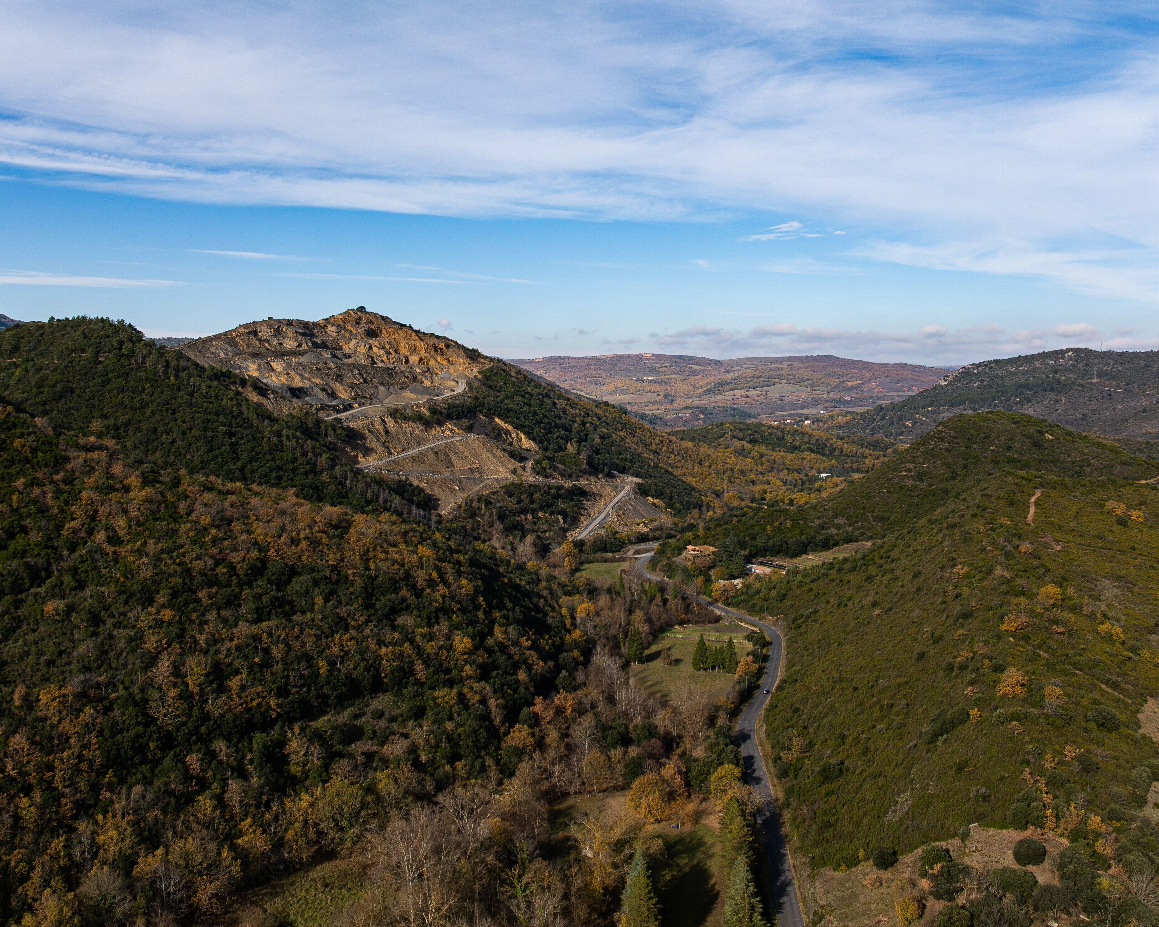 A mountainous landscape with a winding road and a valley.
