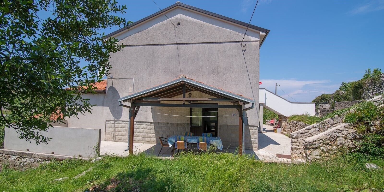 A two-story building with a covered patio area.
