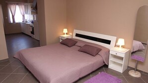 Una camera da letto con un letto, comodini, uno specchio e un bagno con il water e un lavandino.