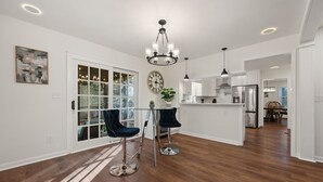 A spacious kitchen with white cabinets, a stainless steel refrigerator, and a large island. - 5BR Smyrna Home Near the Battery (Smyrna)