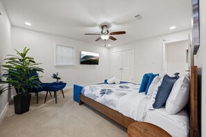 A bedroom with a bed, a ceiling fan, a potted plant, a desk, and a chair. - 5BR Smyrna Home Near the Battery (Smyrna)