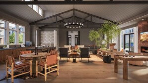 Un interior espacioso con techo alto, vigas de madera, un amplio comedor y una zona de estar acogedora con chimenea.