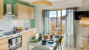 Eine moderne Küche mit Essbereich, großen Fenstern und Blick auf die Stadt.