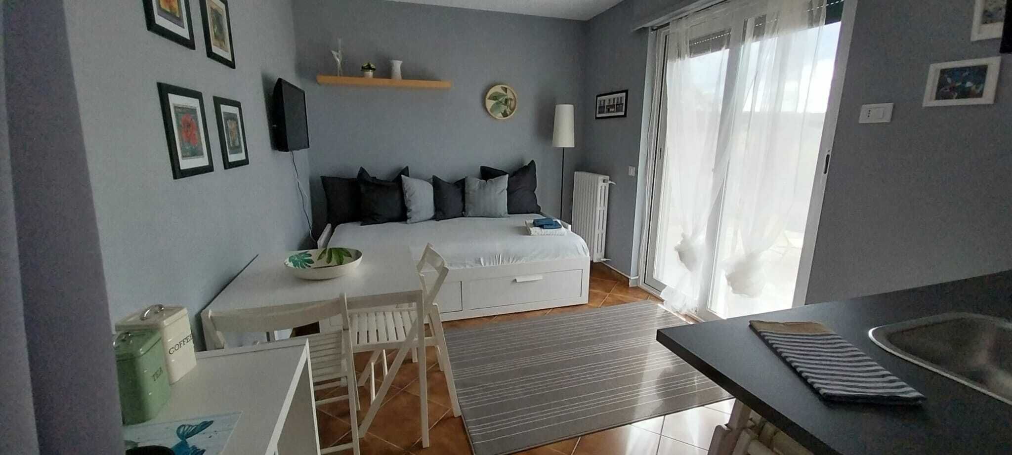 Ein Schlafzimmer mit Bett, Nachttisch und einem Fenster mit Vorhängen.