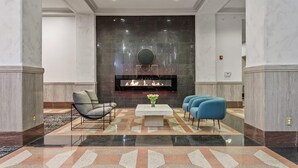 A lobby with a fireplace, seating area, and a checkered floor. - Landing | Chic 2BD, Gym, Pool (Kansas City)