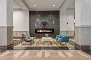 A lobby with a fireplace, seating area, and a checkered floor. - Landing | Chic Studio, Pool, Yoga Studio (Kansas City)