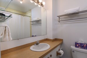 A bathroom with a sink, mirror, towel rack, and toilet. - Village Edge – Steps to the slopes at Sugarbush! (Warren)
