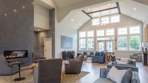 A spacious living area with a fireplace, comfortable seating, and large windows allowing natural light. - Landing Apartments Vernon (Vernon)