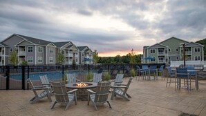 A poolside area with outdoor seating and a fire pit. - Landing Apartments Vernon (Vernon)