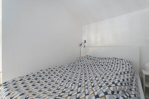 Tabla de planchar con plancha y ropa de cama 