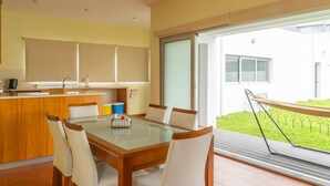 Een moderne keuken met een eethoek, een groot raam en een balkon.