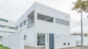 Een modern gebouw met twee verdiepingen, een plat dak, grote ramen en een duidelijke deur.