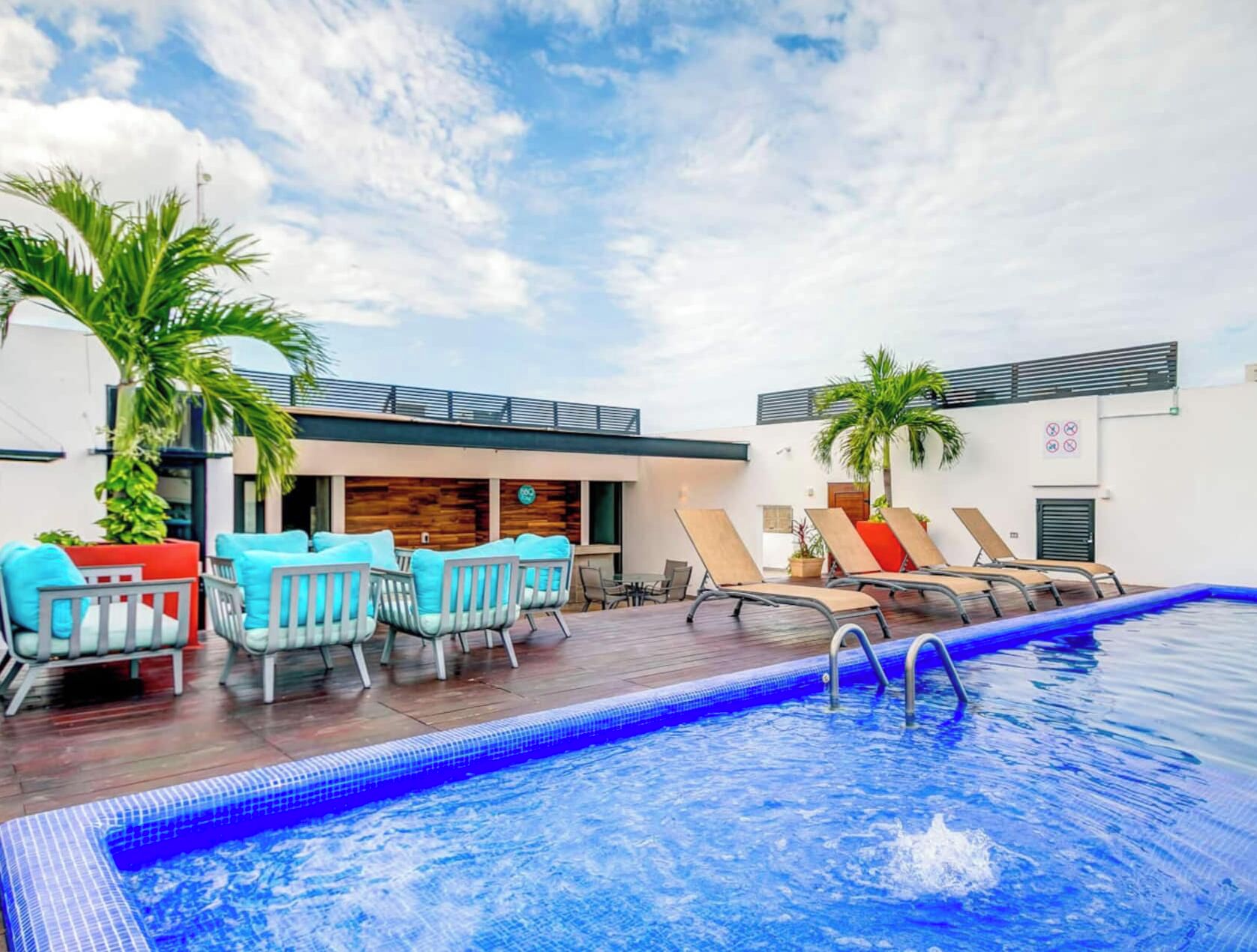 A swimming pool with lounge chairs and a wooden deck.