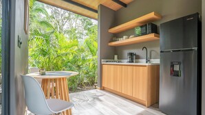 Eine moderne Küche mit Holzausbau, einem schwarzen Kühlschrank und einer eingebauten Mikrowellenregal.